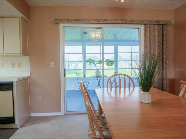 unfurnished dining area featuring light colored carpet and a textured ceiling