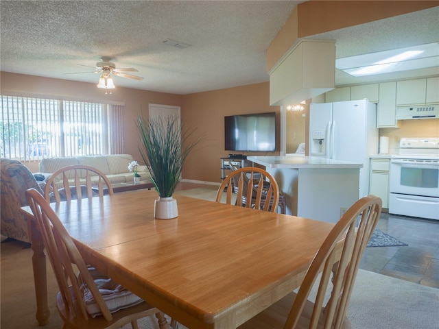 dining space with ceiling fan and a textured ceiling