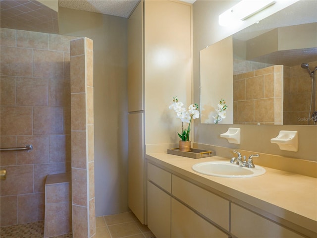 bathroom with vanity, tile patterned flooring, a textured ceiling, and a tile shower