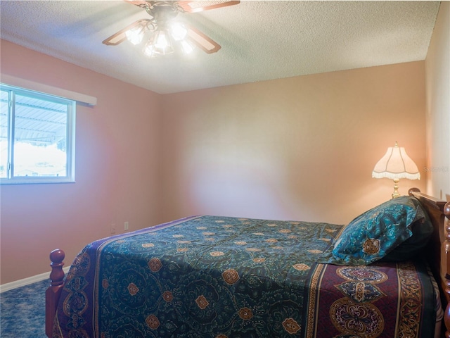 carpeted bedroom with ceiling fan and a textured ceiling