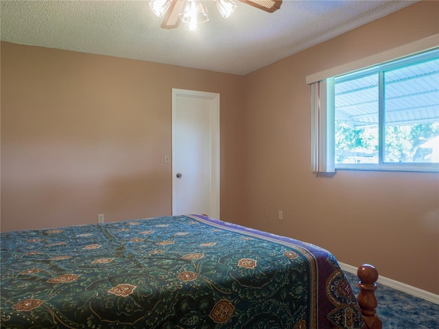 carpeted bedroom featuring a textured ceiling and ceiling fan