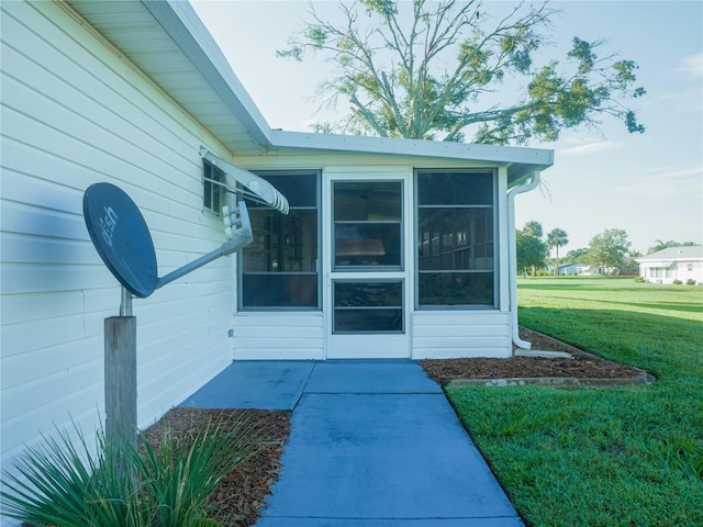 property entrance featuring a lawn