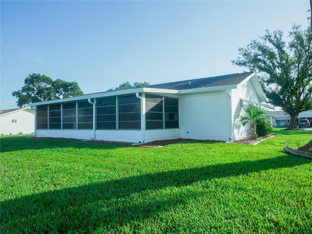 back of house with a lawn and a sunroom