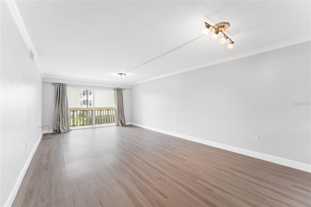 unfurnished room with crown molding, a textured ceiling, and hardwood / wood-style flooring