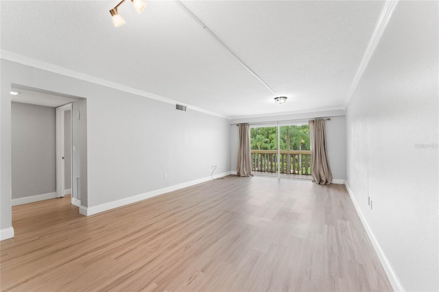 empty room featuring crown molding, a textured ceiling, and light wood-type flooring