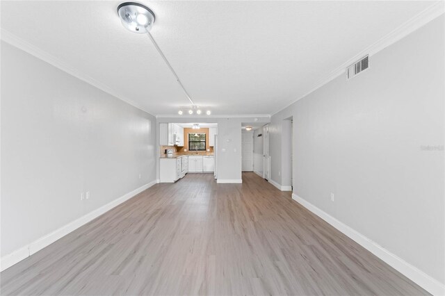 unfurnished living room with crown molding and light hardwood / wood-style flooring