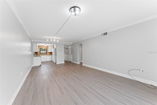 unfurnished living room with crown molding and light hardwood / wood-style flooring