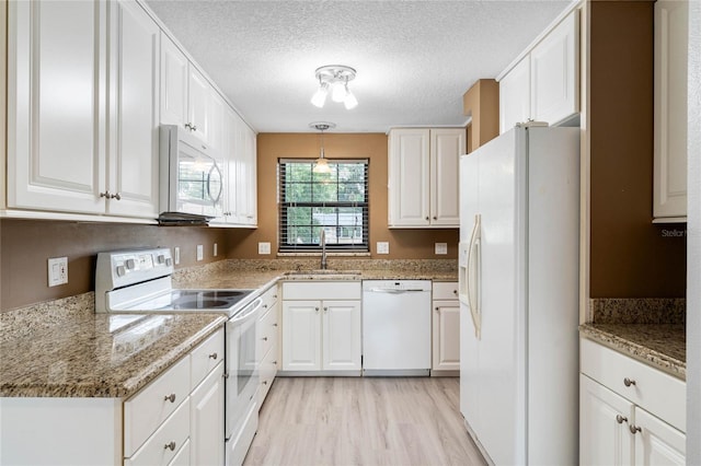 kitchen featuring sink, white cabinets, and white appliances