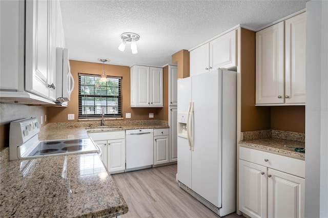 kitchen with white appliances, sink, hanging light fixtures, and white cabinets