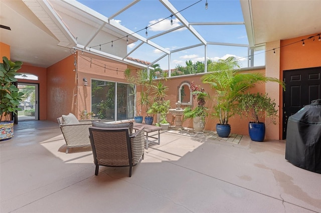 view of patio with an outdoor hangout area and glass enclosure