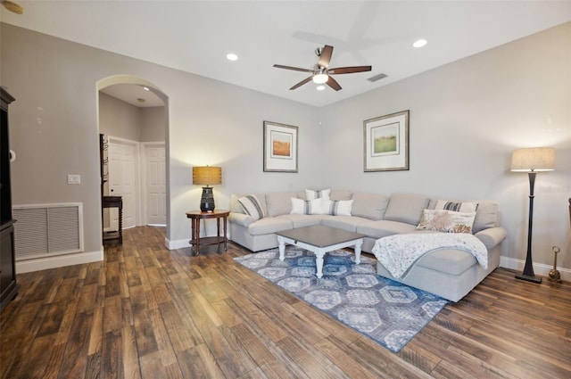 living room featuring ceiling fan and dark hardwood / wood-style flooring