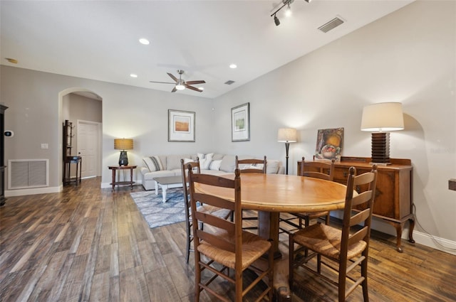 dining space with dark wood-type flooring, ceiling fan, and rail lighting