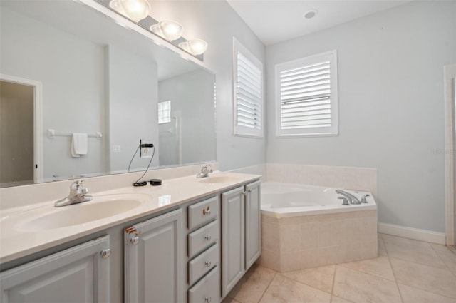 bathroom featuring tile patterned flooring, vanity, and tiled tub