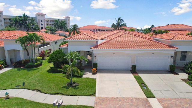 mediterranean / spanish home with a garage and a front yard