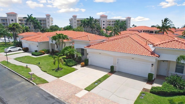 mediterranean / spanish house featuring a garage and a front lawn