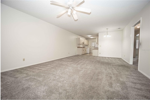 unfurnished living room featuring a textured ceiling, ceiling fan with notable chandelier, and light colored carpet