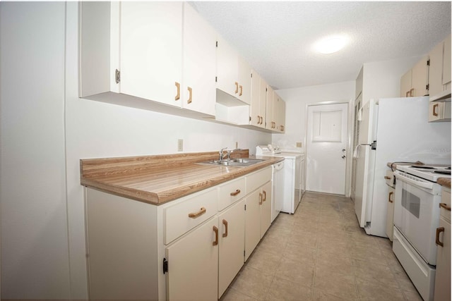 kitchen featuring white cabinets, white appliances, sink, separate washer and dryer, and light tile patterned floors