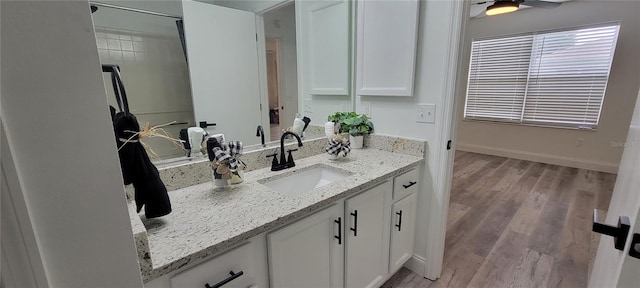 bathroom featuring vanity, wood-type flooring, and a tile shower