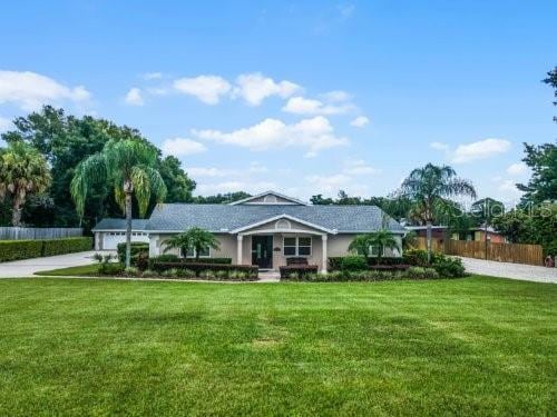 single story home featuring a front yard and a garage