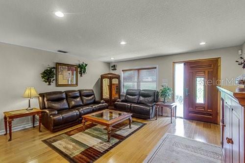 living room featuring a textured ceiling and light wood-type flooring