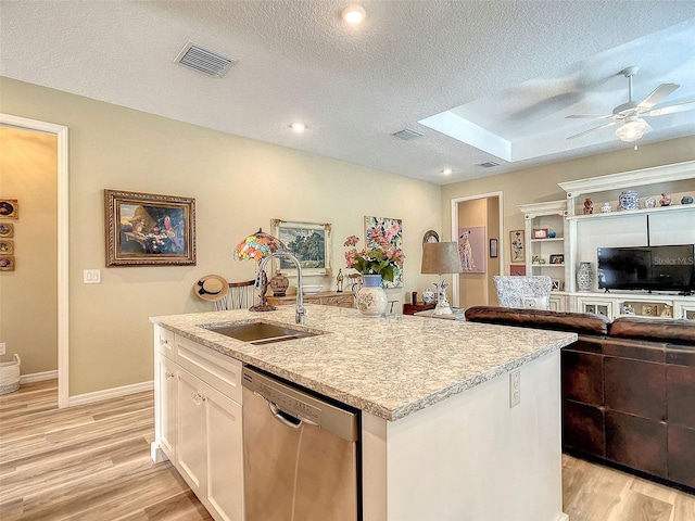 kitchen featuring white cabinets, sink, dishwasher, light hardwood / wood-style floors, and a textured ceiling