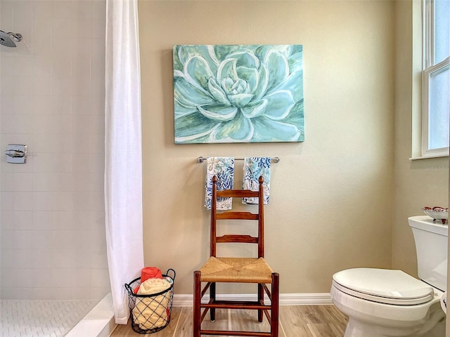 bathroom featuring hardwood / wood-style flooring, toilet, and a shower with shower curtain