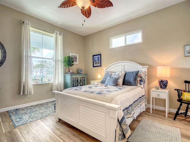 bedroom featuring light hardwood / wood-style floors, multiple windows, and ceiling fan