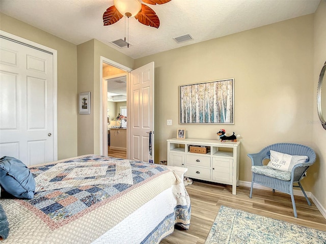 bedroom with ceiling fan, a textured ceiling, light hardwood / wood-style flooring, and a closet