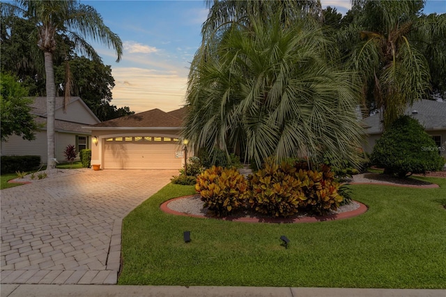 view of front of house with a garage and a lawn