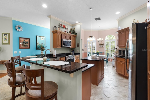 kitchen with a kitchen island, pendant lighting, sink, stainless steel appliances, and crown molding