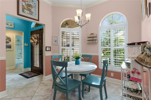 dining space with crown molding, a wealth of natural light, an inviting chandelier, and light tile patterned flooring