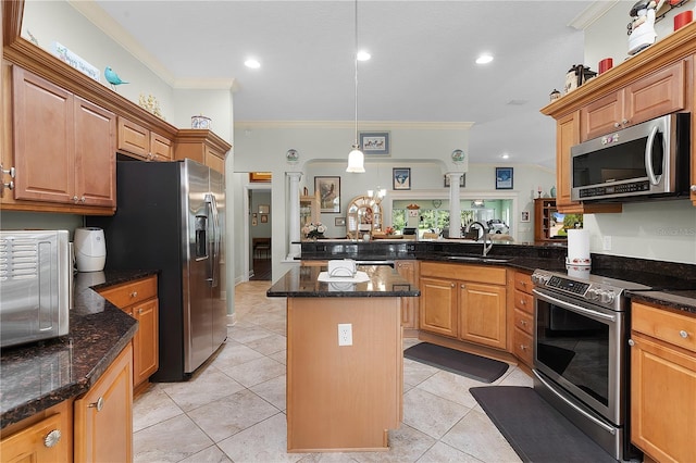 kitchen featuring crown molding, appliances with stainless steel finishes, a center island, and light tile patterned flooring