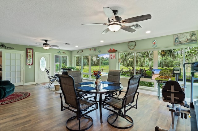 dining room featuring hardwood / wood-style floors, a textured ceiling, and ceiling fan