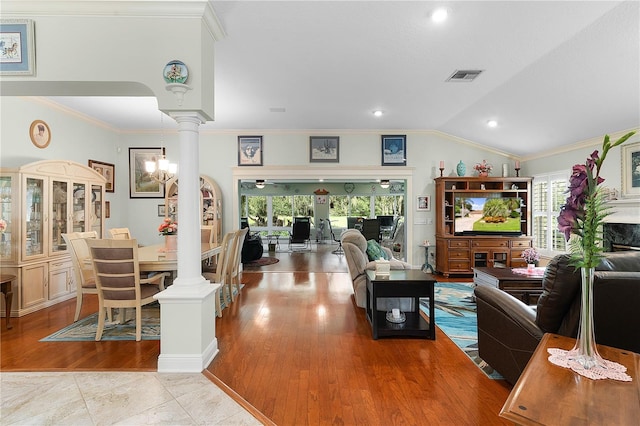 living room with lofted ceiling, a healthy amount of sunlight, ornamental molding, and ornate columns