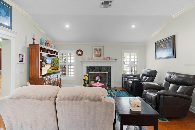 living room featuring wood-type flooring, a fireplace, vaulted ceiling, and plenty of natural light