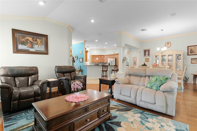 living room featuring hardwood / wood-style flooring, ornamental molding, lofted ceiling, and ornate columns