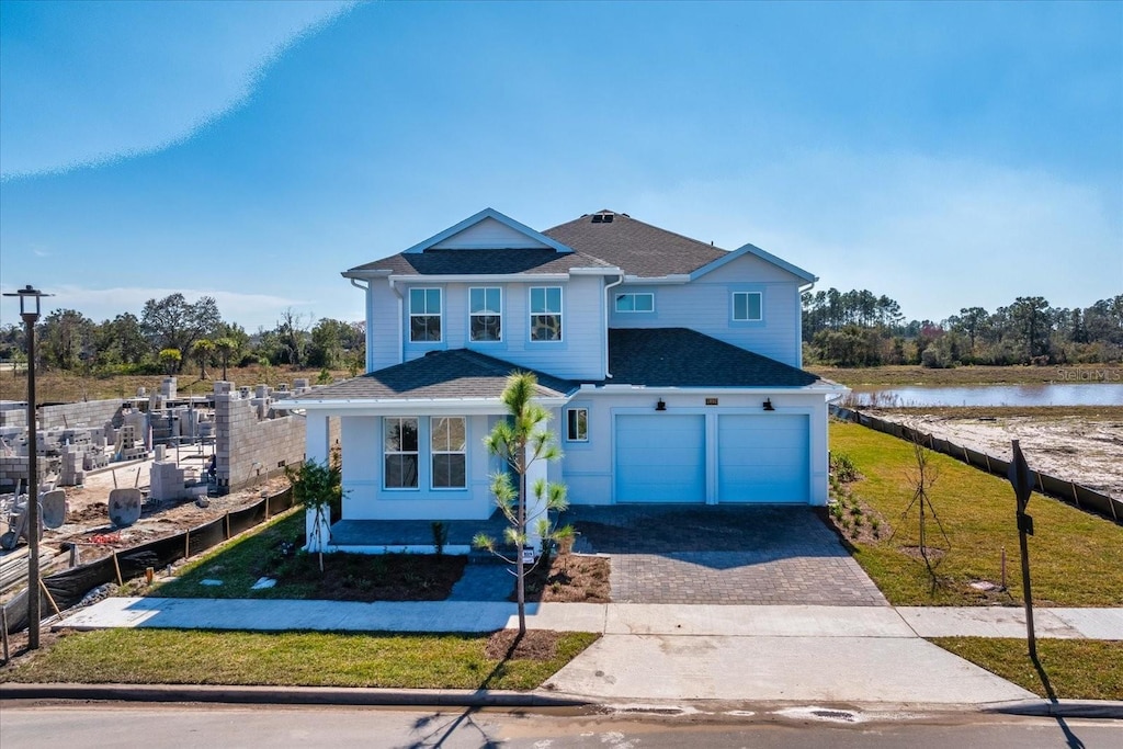 front facade featuring a garage and a water view