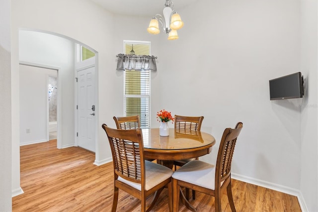 dining area featuring light hardwood / wood-style flooring and a chandelier