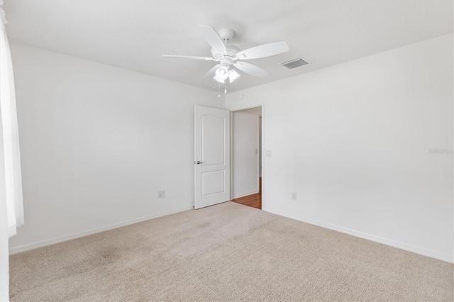 unfurnished room with ceiling fan and light colored carpet