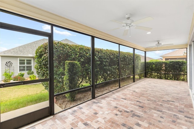 unfurnished sunroom with ceiling fan