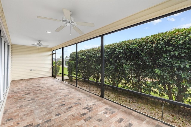 unfurnished sunroom with ceiling fan