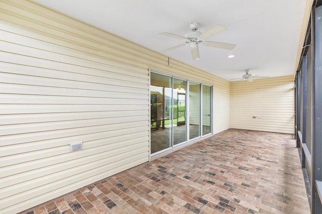 unfurnished sunroom with ceiling fan