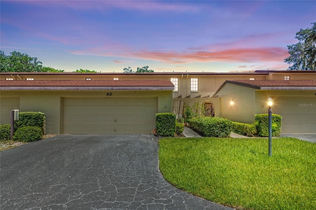 view of front of property featuring a garage and a yard