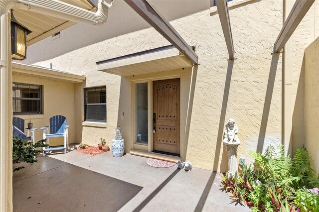 view of exterior entry featuring a patio area