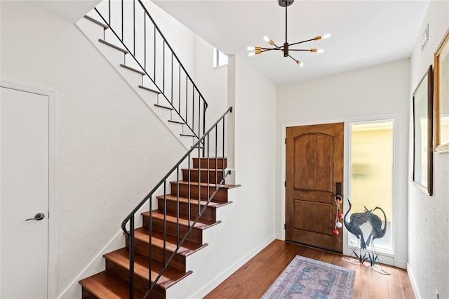 foyer entrance with hardwood / wood-style flooring and a chandelier