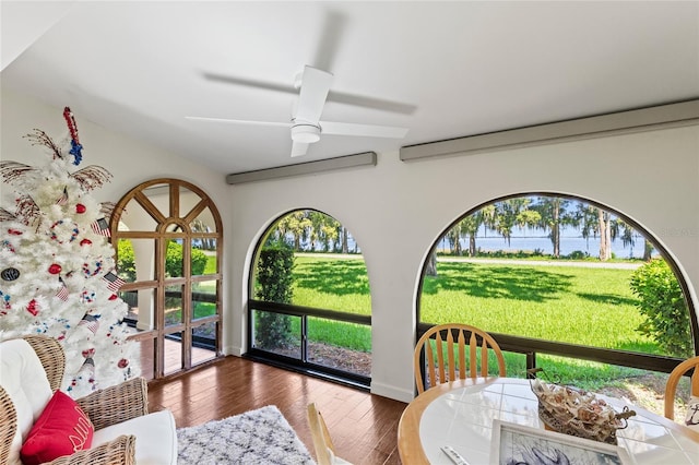 sunroom with ceiling fan, a water view, and plenty of natural light