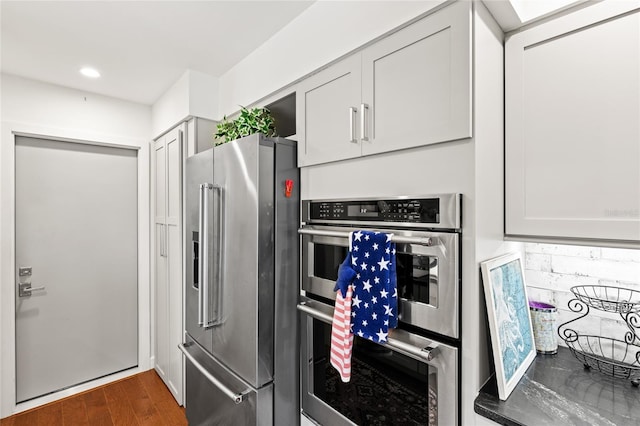 kitchen with appliances with stainless steel finishes and hardwood / wood-style flooring