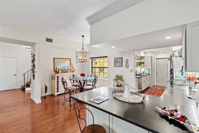 dining space with a notable chandelier, sink, and dark hardwood / wood-style floors