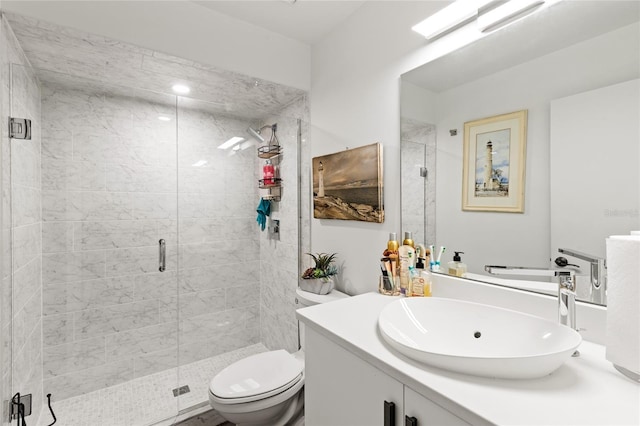 bathroom featuring toilet, a shower with shower door, and vanity