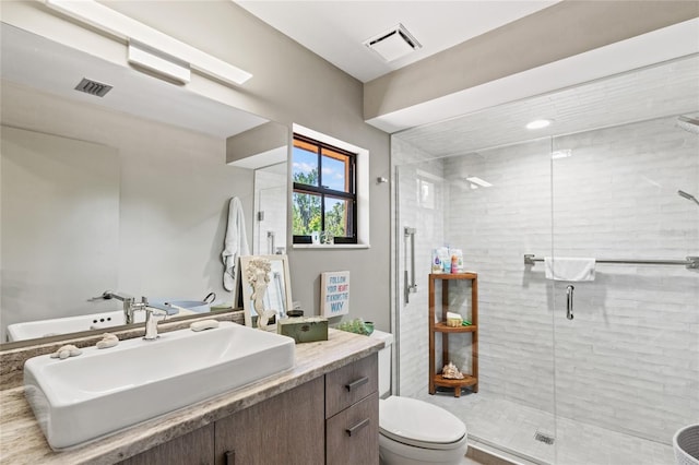 bathroom with toilet, vanity, and an enclosed shower